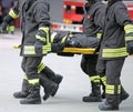 Firefighters carry a wounded man on a stretcher Royalty Free Stock Photo