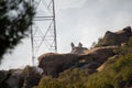 Firefighters climb rocks and use a hose on a brush fire in Chatsworth, California