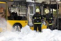 Firefighters extinguish burning public transit bus with foam