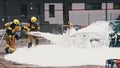 Firefighters extinguish fire from the burning car using foam