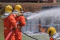 Firefighters extinguish the fire with chemical foam coming from the fire engine through a long hose