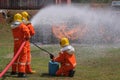 Firefighters extinguish the fire with a chemical foam coming from the fire engine through long hose