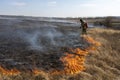 Firefighters extinguish the flames of burning grass