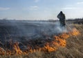 Firefighters extinguish the flames of burning grass