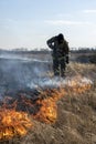 Firefighters extinguish the flames of burning grass