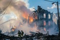 Firefighters fighting a fire in a burned house in the city Royalty Free Stock Photo