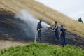 Firefighters flood the effects of dry grass fire Royalty Free Stock Photo