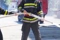 Firefighters holding firehose to extinguish fire Royalty Free Stock Photo