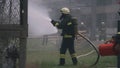 Firefighters pouring water from hoses on lawn