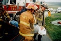 Firefighters remove an injured person from an auto accident