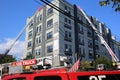 Firefighters rescue people in high modern building to escape by extended ladder crane of fire truck, fire drill