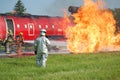 Firefighters in SCBA fight simulated fuel fire with hose line