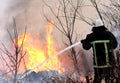 Firefighters spray water to wildfire. firefighter extinguishes a