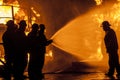 Firefighters spraying burning structure with water Royalty Free Stock Photo