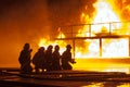 Firefighters spraying down burning structure during firefighting exercise