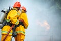 Firefighters spraying high pressure water to fire with copy space, Big bonfire in training, Firefighter wearing a fire suit for Royalty Free Stock Photo