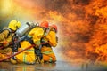 Firefighters spraying high pressure water to fire with copy space, Big bonfire in training, Firefighter wearing a fire suit for