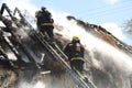 Firefighters tackle a thatch roof fire Royalty Free Stock Photo