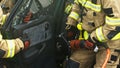 Firefighters using jaws of life to extricate trapped victim from the car Royalty Free Stock Photo