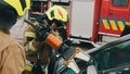 Firefighters using jaws of life to extricate trapped victim from the car Royalty Free Stock Photo