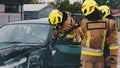 Firefighters using jaws of life to extricate trapped victim from the car