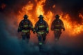 Firefighters walk through intense fire, smoke. Emergency response team moves forward bravely. Dramatic image of heroism. Royalty Free Stock Photo