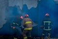 Firefighters work on an fire of building using a metal cutter rescue tool during a fire. fire extinguish Royalty Free Stock Photo