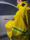 Firefighters with yellow suit holding helmet try to save life