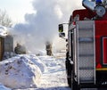 Firefighting. A fire truck and firemen at work. A lot of smoke. Winter season. Russia