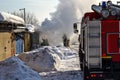 Firefighting. A fire truck and firemen at work. A lot of smoke. Winter season. Russia