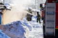 Firefighting. A fire truck and firemen at work. A lot of smoke. Winter season. Russia