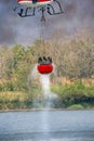 Firefighting helicopter refills water bucket in a pond