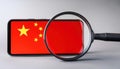 Firefly smartphone displaying Chinese flag under magnifying glass suggesting surveillance concerns in modern technology