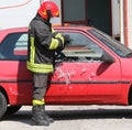 fireman while breaking the glass of a car with a special equipment Royalty Free Stock Photo