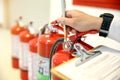 Fireman are checking and inspection red tank of fire extinguisher.