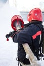 Fireman extinguish fire by foam spraying hose Royalty Free Stock Photo