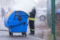 A fireman extinguishing a waste bin for paper Royalty Free Stock Photo