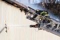 Fireman fighting a building fire at the top of an extended ladder