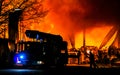 Fireman and fire truck at a large building fire at night