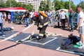 A fireman in a fireproof suit and a helmet holding a fire hose at a fire sport competition. Minsk, Belarus, 08.07.2018