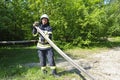 Fireman folding a hose up after fire fighting