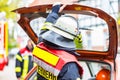 Fireman with helmet holds his hand on car bootlid Royalty Free Stock Photo