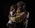 Fireman holding little girl on black