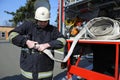 Fireman joining syringe of a water cannon to a hose before firefighting