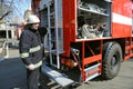 Fireman preparing firefighting equipment near firetruck before firefighting