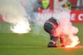 Fireman remove flares from the football pitch
