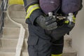 A fireman`s hand opens a cylinder with compressed air for breathing in a smoky room, close-up, back view