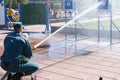 A fireman`s man is teaching a child, a girl to put out a fire by shooting a stream of water from a bronzboyt, a fire hose, a hose Royalty Free Stock Photo