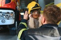 A fireman shows his work to his young son. A boy in a firefighter's helmet Royalty Free Stock Photo