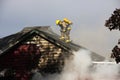 Fireman on top of a burning house Royalty Free Stock Photo
